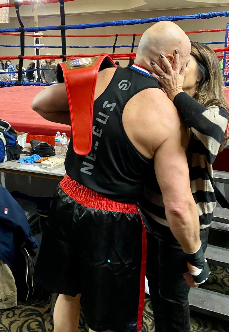 Phil in boxing gear ringside, getting a kiss on the cheek